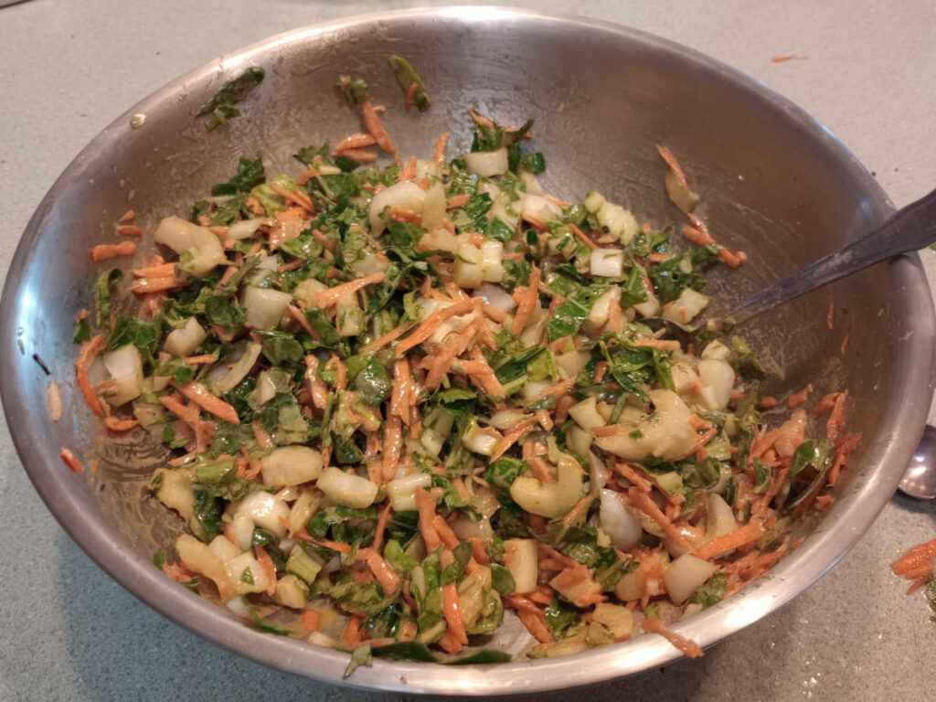 Bok choy coleslaw in mixing bowl