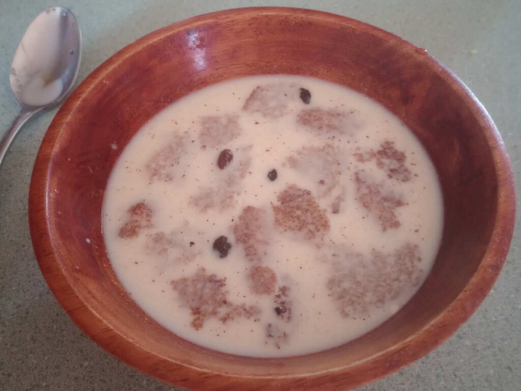 Bread and milk with raisins in wooden bool.