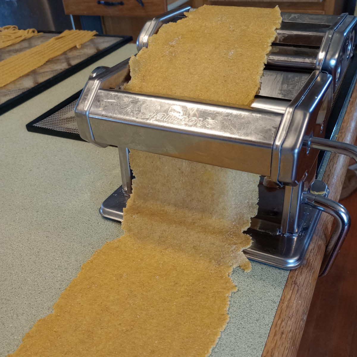 Pasta being rolled in machine